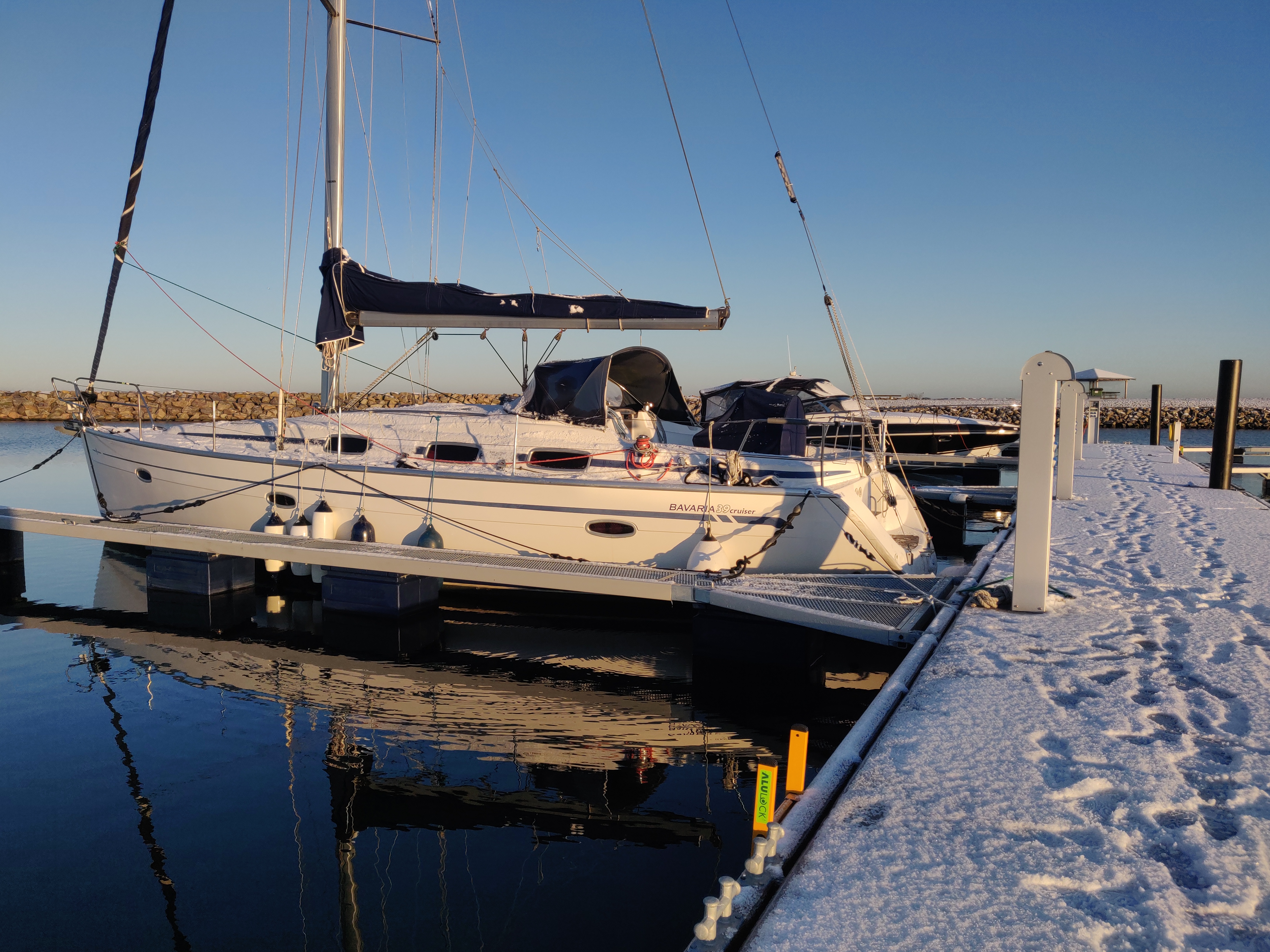 sejlbåd fortøjret i vandet om vinteren med frost og sne